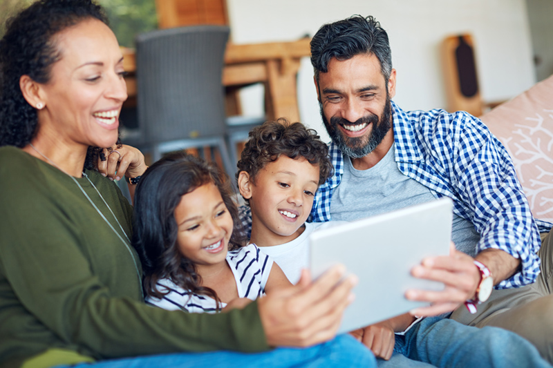 Cropped shot of a happy family using a digital tablet together at home